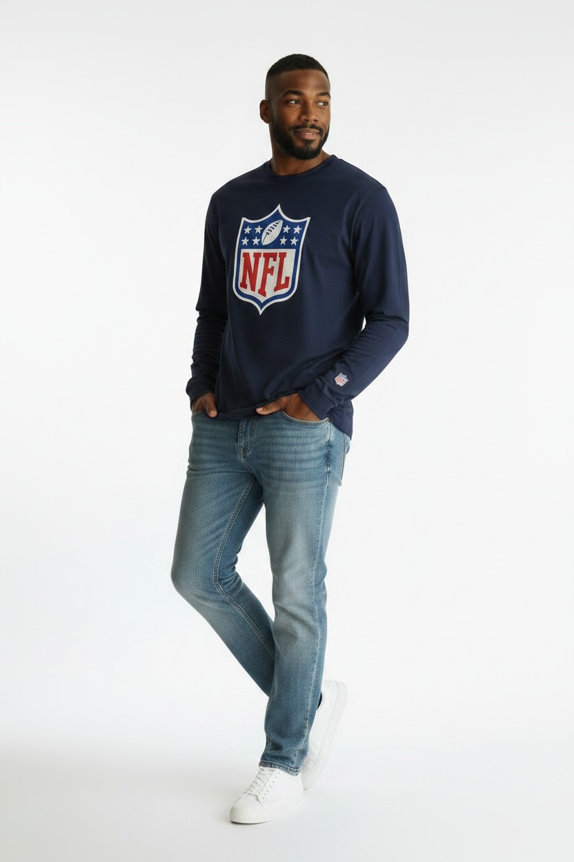 تی‌شرت آستین بلند مردانه سرمه‌ای برند NFL با چاپ بزرگ لوگوی شیلد در نمای فلت لی (Flat Lay)